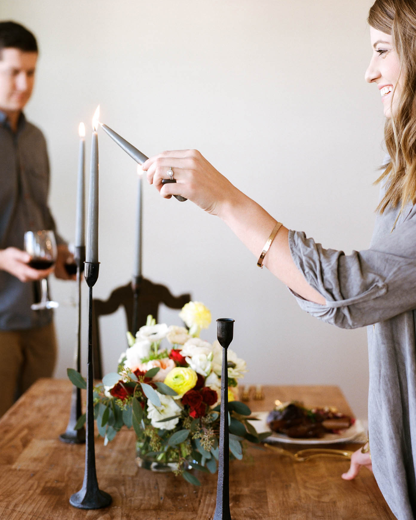 couple setting the table and lighting a candle for dinner