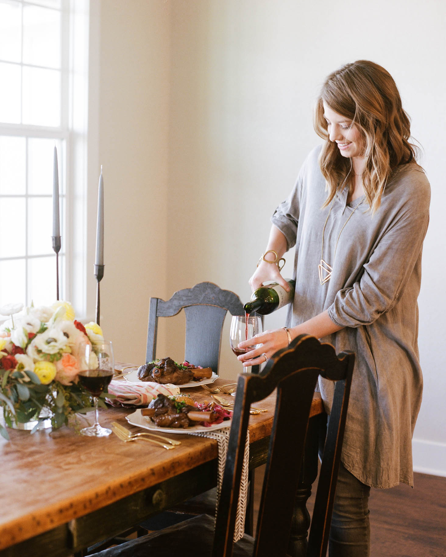 woman pouring a glass of wine before dinner