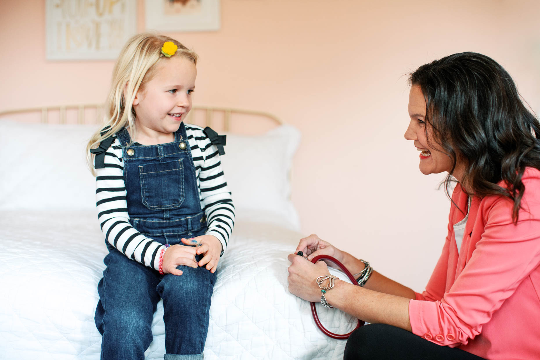 Bright photo of a young girl interacting with a warm and friendly healthcare provider in a home setting