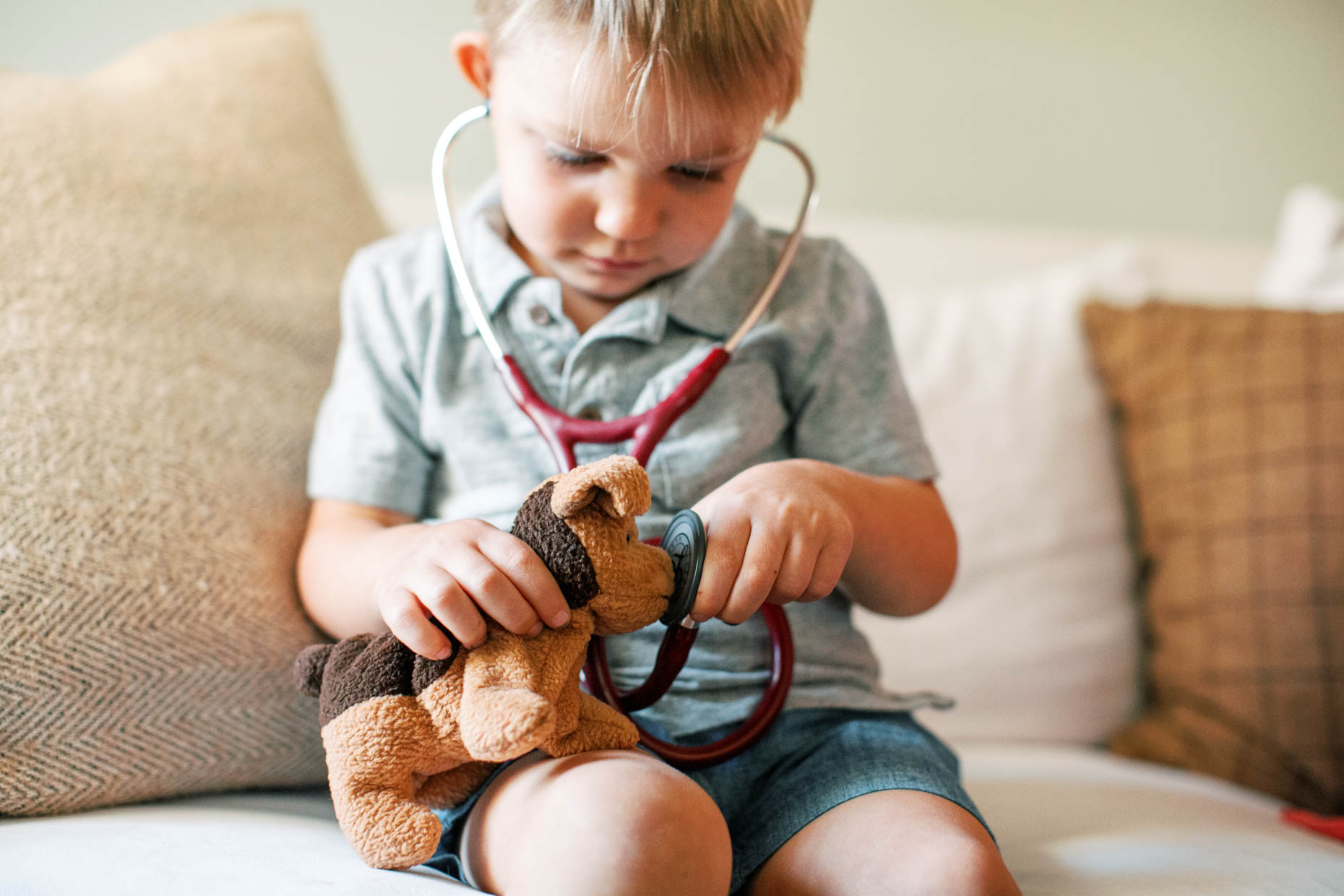little boy holding stuffed animal for a healthcare photo shoot