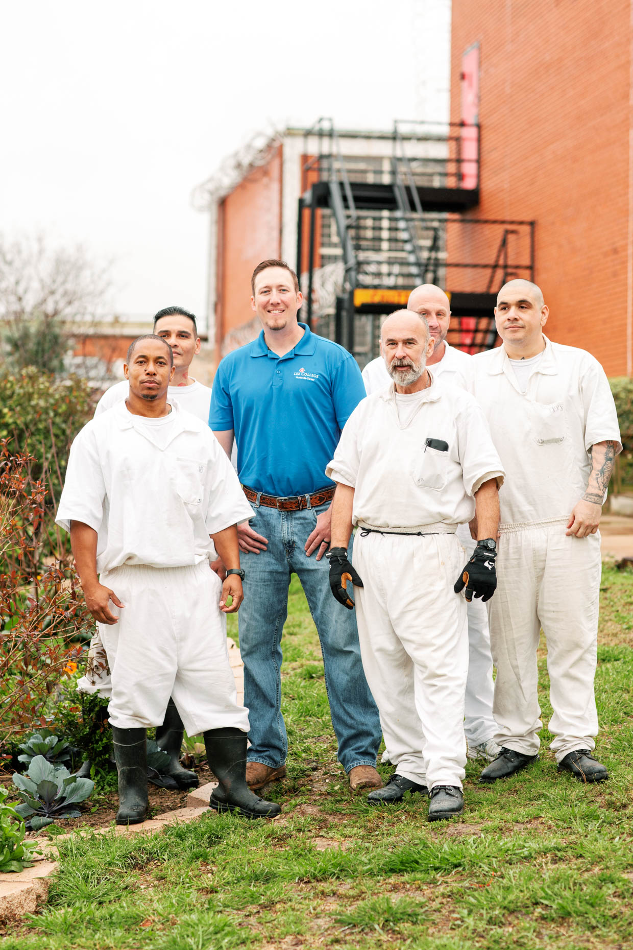 Inmates standing with gardening instructor as part of a prison garden class