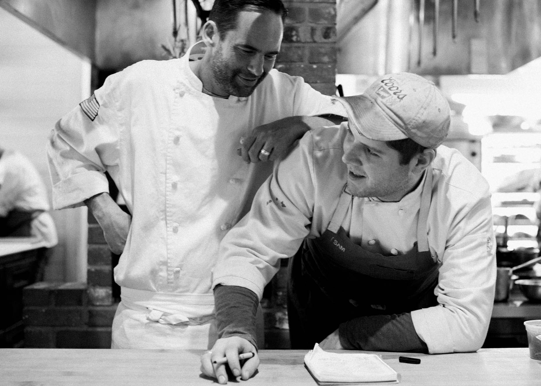 chef and kitchen staff interacting at restaurant brand narrative photos