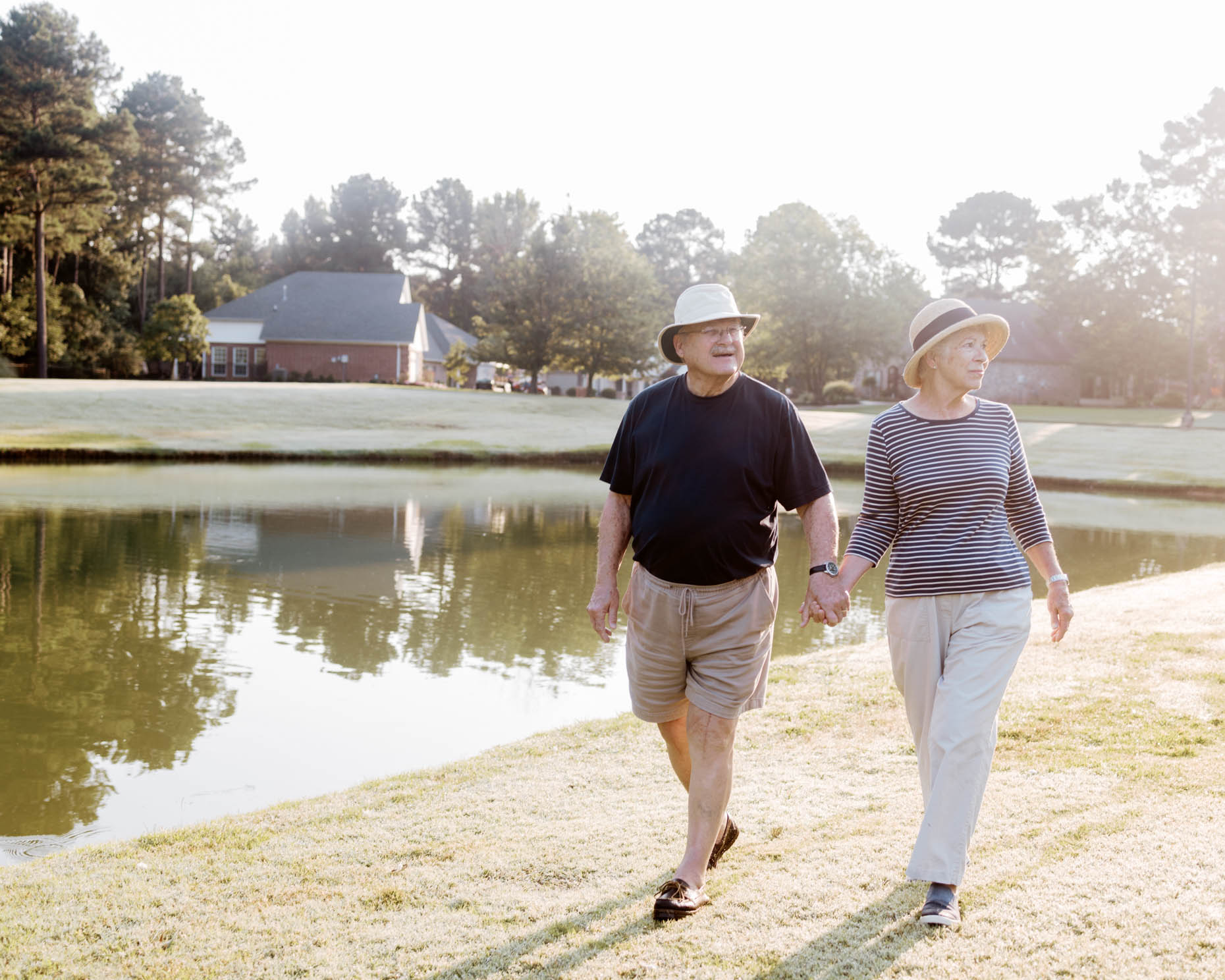 A retired couple walking outdoors in a senior living community for a commercial photo shoot