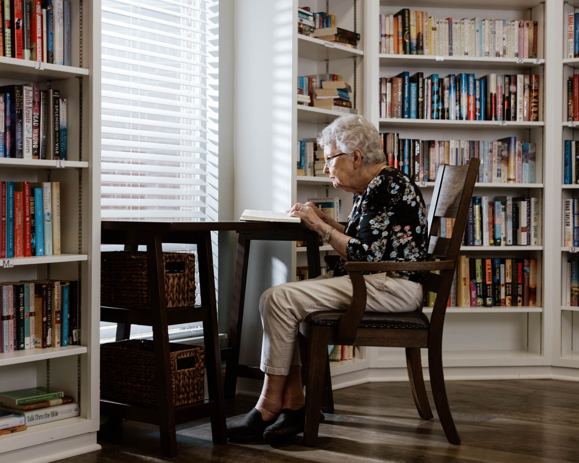 Elderly woman in a library at a senior living community