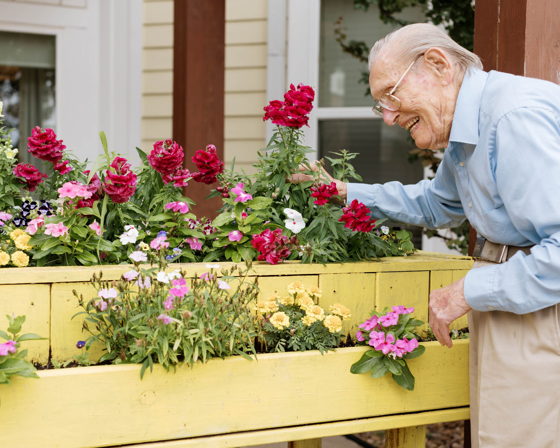 Retired man gardening flowers at a senior living community