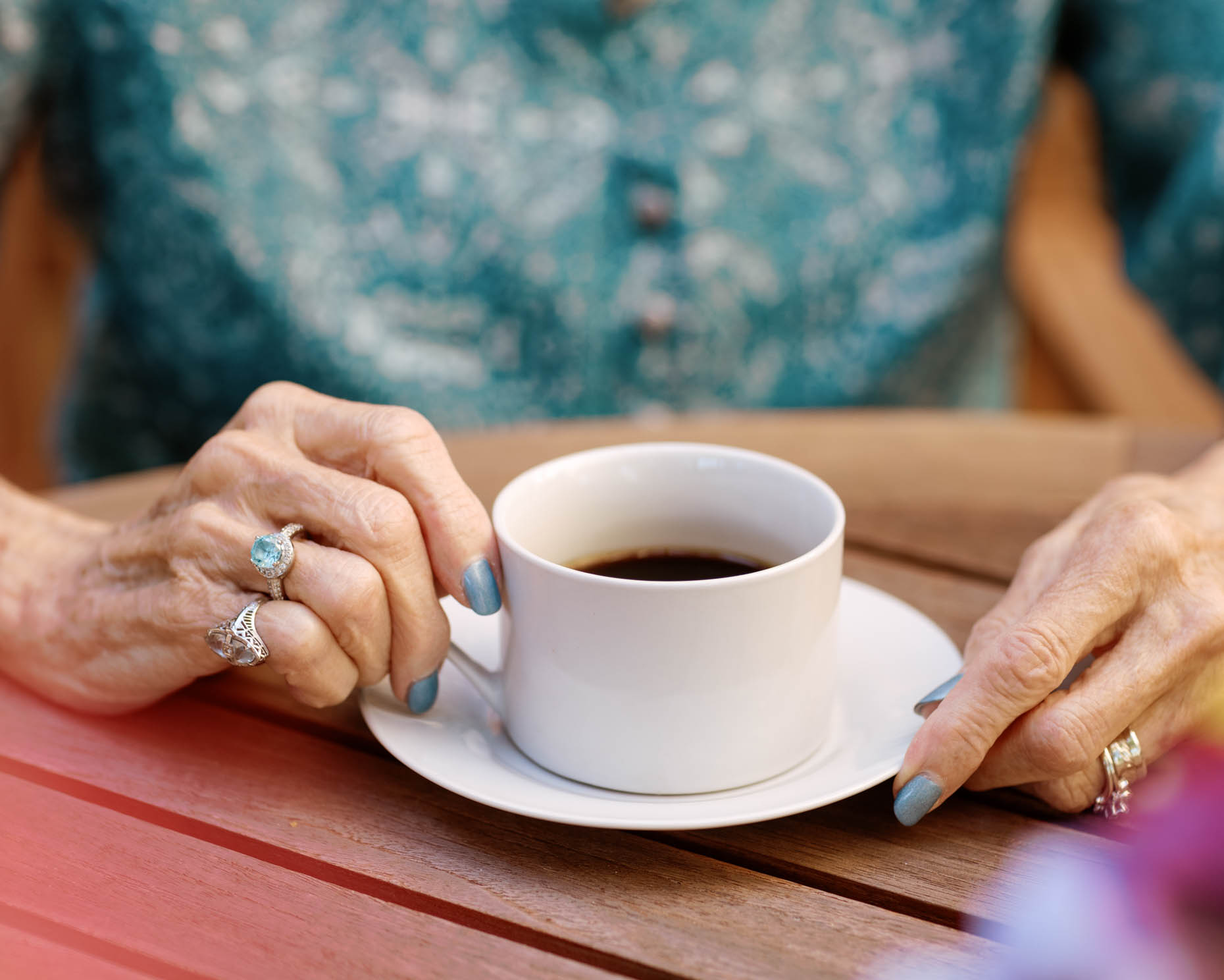 Elderly woman holding coffee at a senior living community