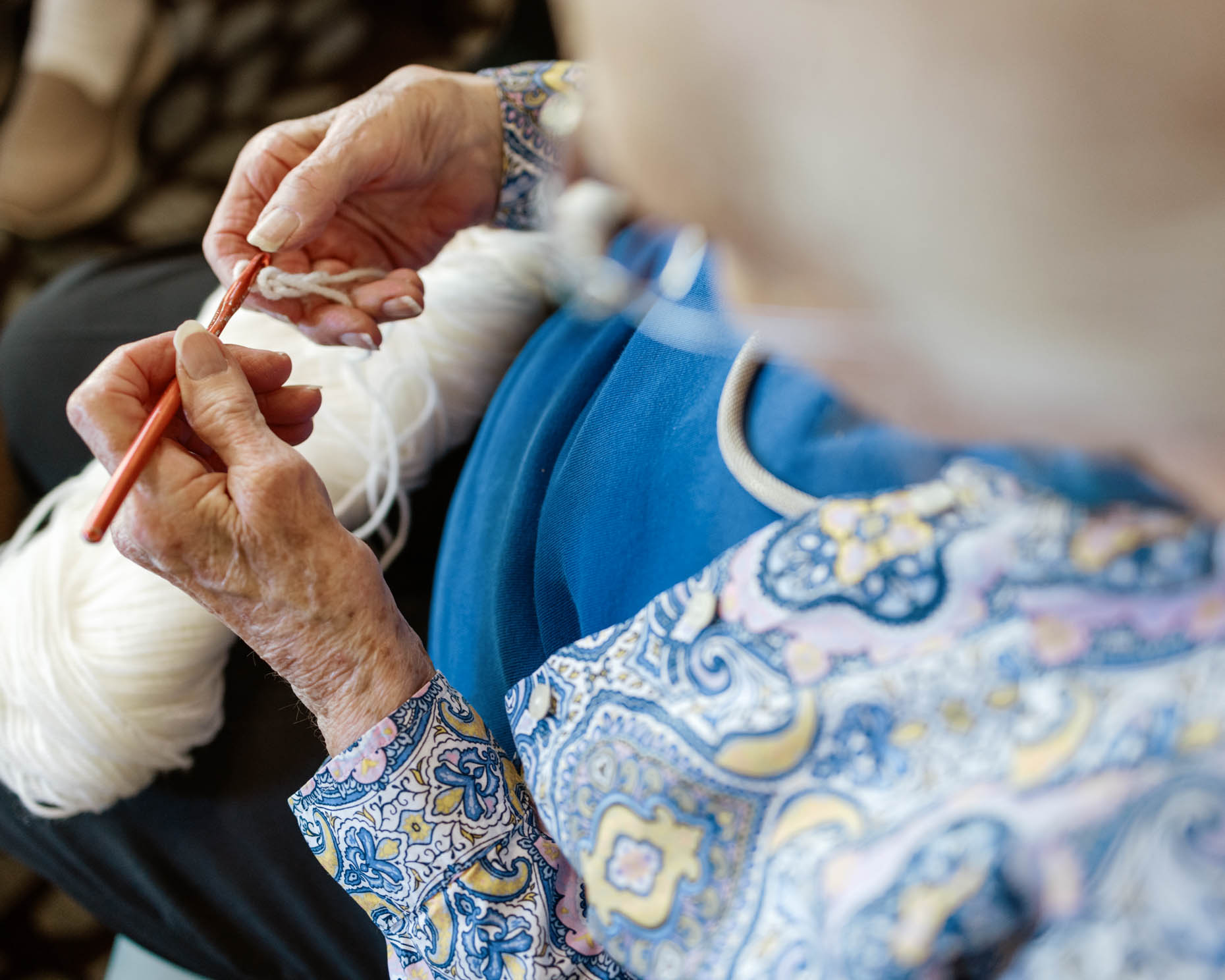 Elderly woman doing needle point at a senior living community