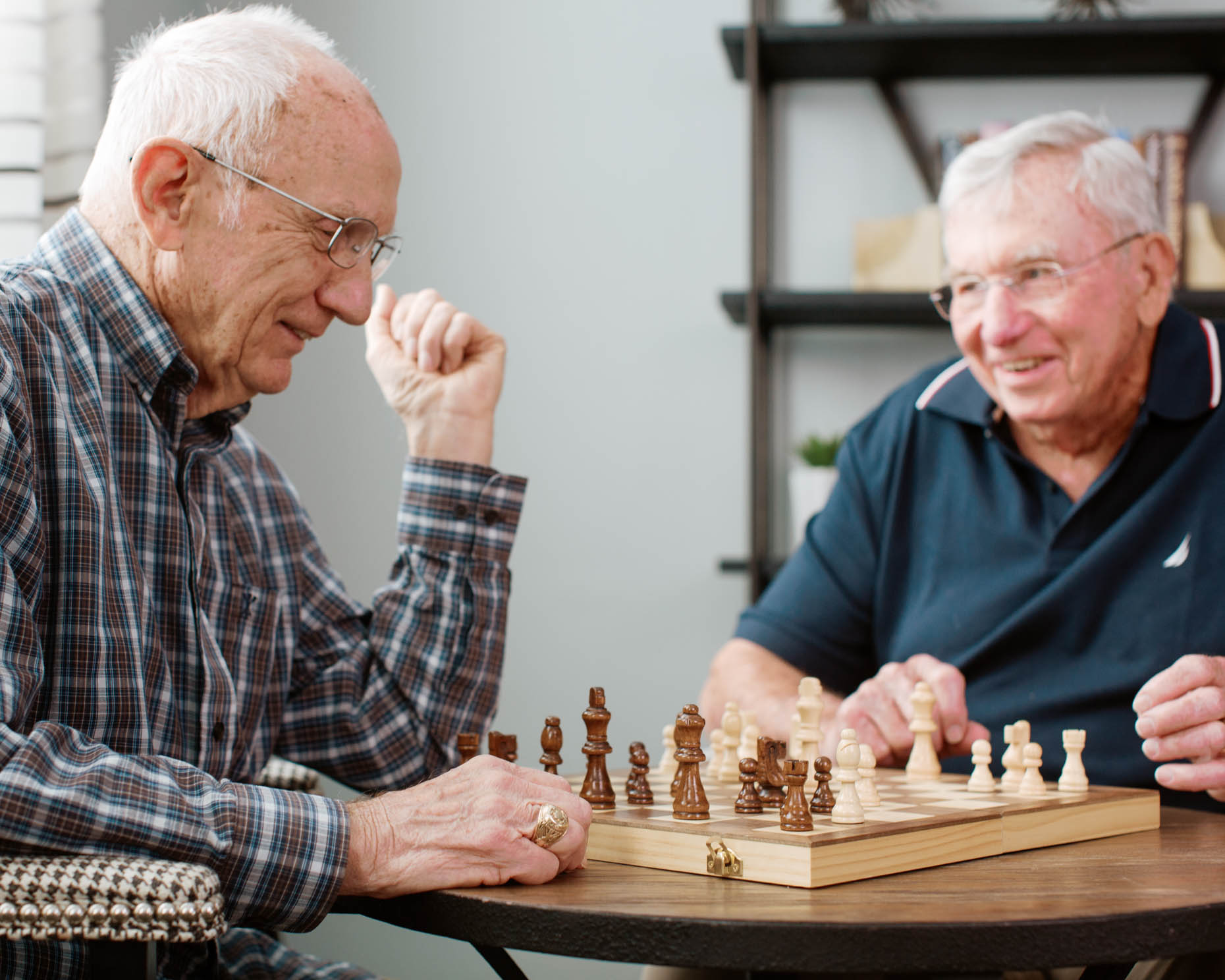 Retired men playing chess together at a senior living community