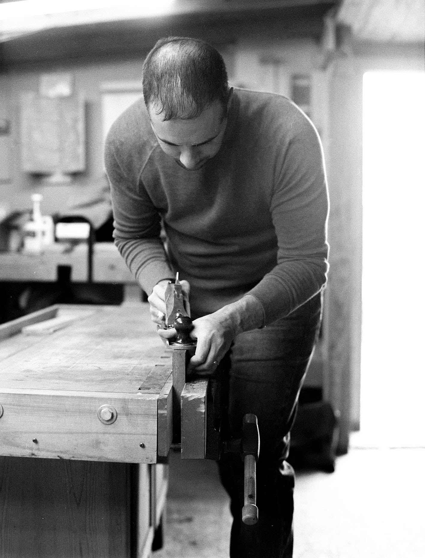 editorial images of a wood worker using a plane